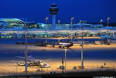 an airport at night with airplanes parked on the tarmac