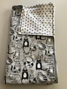 a black and white cat print blanket on top of a wall with polka dot dots