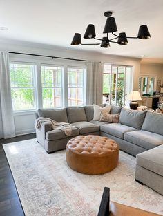 a living room filled with furniture and large windows