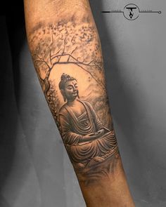 a man's arm with a buddha tattoo on it