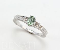 an engagement ring with a green stone in the center