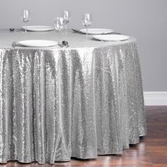 silver sequin tablecloth with white plates and wine glasses