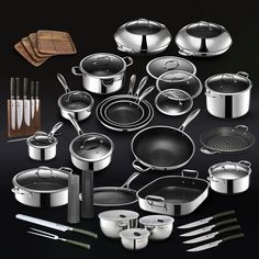 an assortment of pots and pans with utensils on a black table top