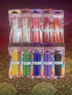 an assortment of different colored candles in plastic bags