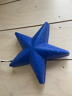 a blue star shaped object is hanging on the wall next to a charger plugged in