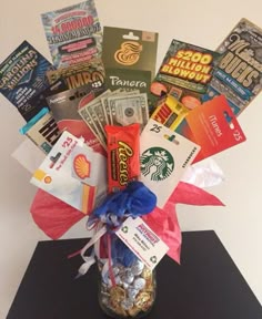 a vase filled with lots of different types of cards and candy in front of a white wall