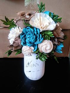 a vase filled with flowers sitting on top of a black table next to a cardboard box