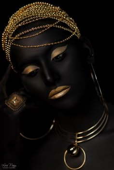 a black mannequin with gold jewelry on her face