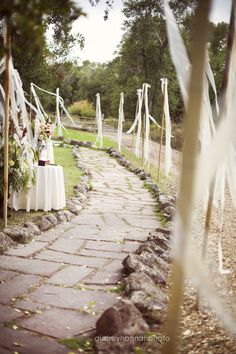 an outdoor ceremony with white draping and flowers on the table set up outside