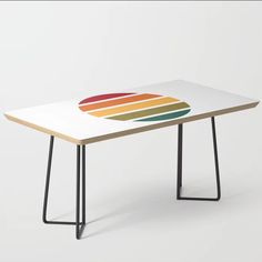 a table with a colorful design on the top and black metal legs, against a white background