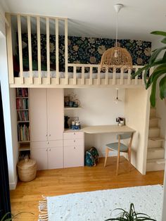 there is a loft bed in the middle of this room with a desk under it