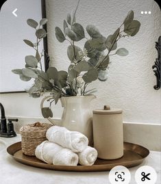 a bathroom sink with towels and a vase filled with flowers