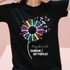 a woman wearing a black rainbow and butterflies t - shirt