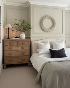 a bedroom with a bed, dresser and mirror on the wall next to each other