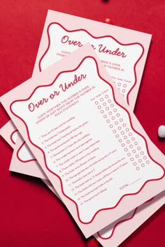 two red and white wedding programs on top of each other with confetti in the background