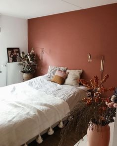 a bedroom with pink walls and white bedding