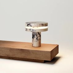 a white and black object sitting on top of a wooden stand