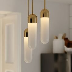 three lights hanging from a ceiling in a kitchen