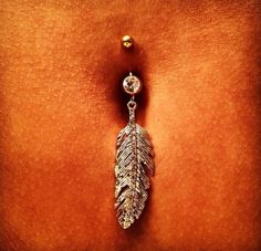 a belly piercing with a leaf design on it