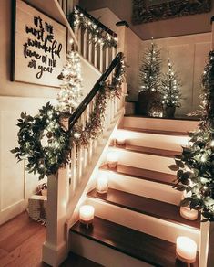 stairs decorated with christmas lights and greenery for the holiday season, lit by candles