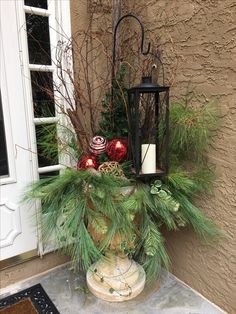 a lantern and christmas decorations on a porch