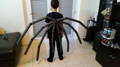 a young boy standing in front of a giant spider