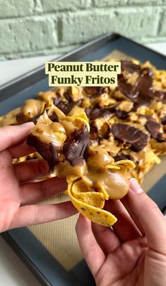 a person is holding some food in front of a tray with chocolate and peanut butter funky fritos