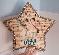 an ornament shaped like a star with the words joy and two girls on it