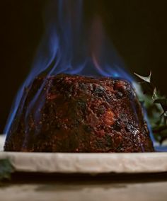 a piece of meat on a plate with blue flames coming out of the top and bottom