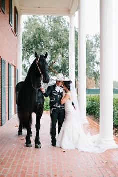 a bride and groom standing next to a horse