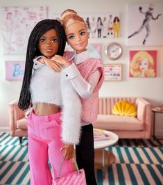 two barbie dolls standing next to each other in a room with pink furniture and striped carpet