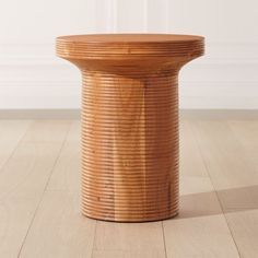 a wooden table sitting on top of a hard wood floor next to a white wall