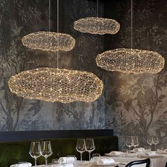 a dining room with tables, chairs and chandeliers hanging from the ceiling above them