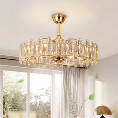 a chandelier hanging from the ceiling in a living room with white walls and windows