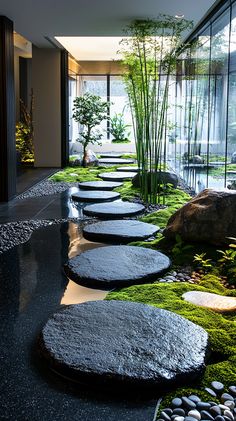 an indoor garden with stepping stones and moss growing on the ground in front of it