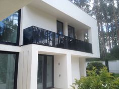 a white house with black balconies and windows