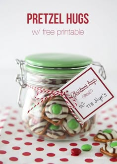 a glass jar filled with candy and pretzels on top of a polka dot table cloth