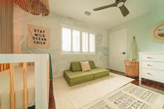 a baby's room with a green couch and white crib