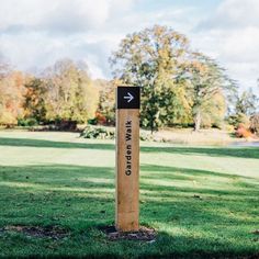 a wooden sign that says the way to god's grace in front of a grassy field