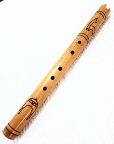 a wooden flute with black dots on it