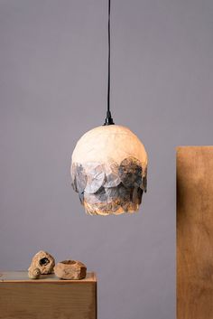 a lamp hanging from a ceiling next to a wooden block