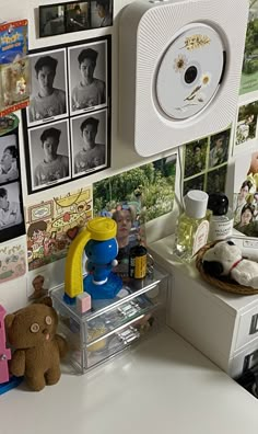 an office desk with pictures on the wall and a stuffed animal in front of it