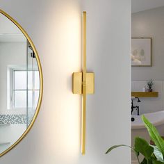 a bathroom with a sink, mirror and bathtub in the corner next to a potted plant