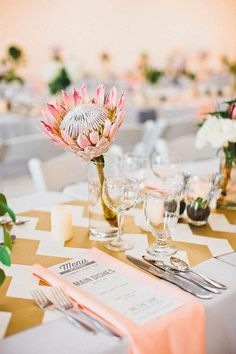 the table is set with silverware and pink flowers