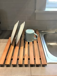 there is a coffee cup and two surfboards on the kitchen counter next to the sink