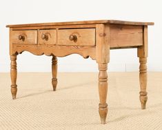 an old wooden table with three drawers on one side and two turned down legs at the bottom