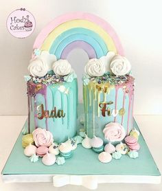 two cakes decorated with rainbows and flowers on a table