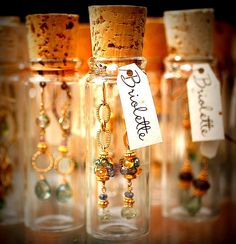 some glass bottles with necklaces in them