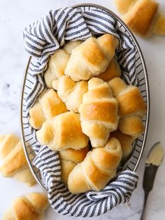 a bowl filled with rolls sitting on top of a table