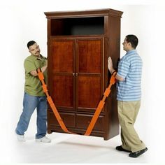 two men standing next to each other in front of a wooden cabinet with orange straps on it